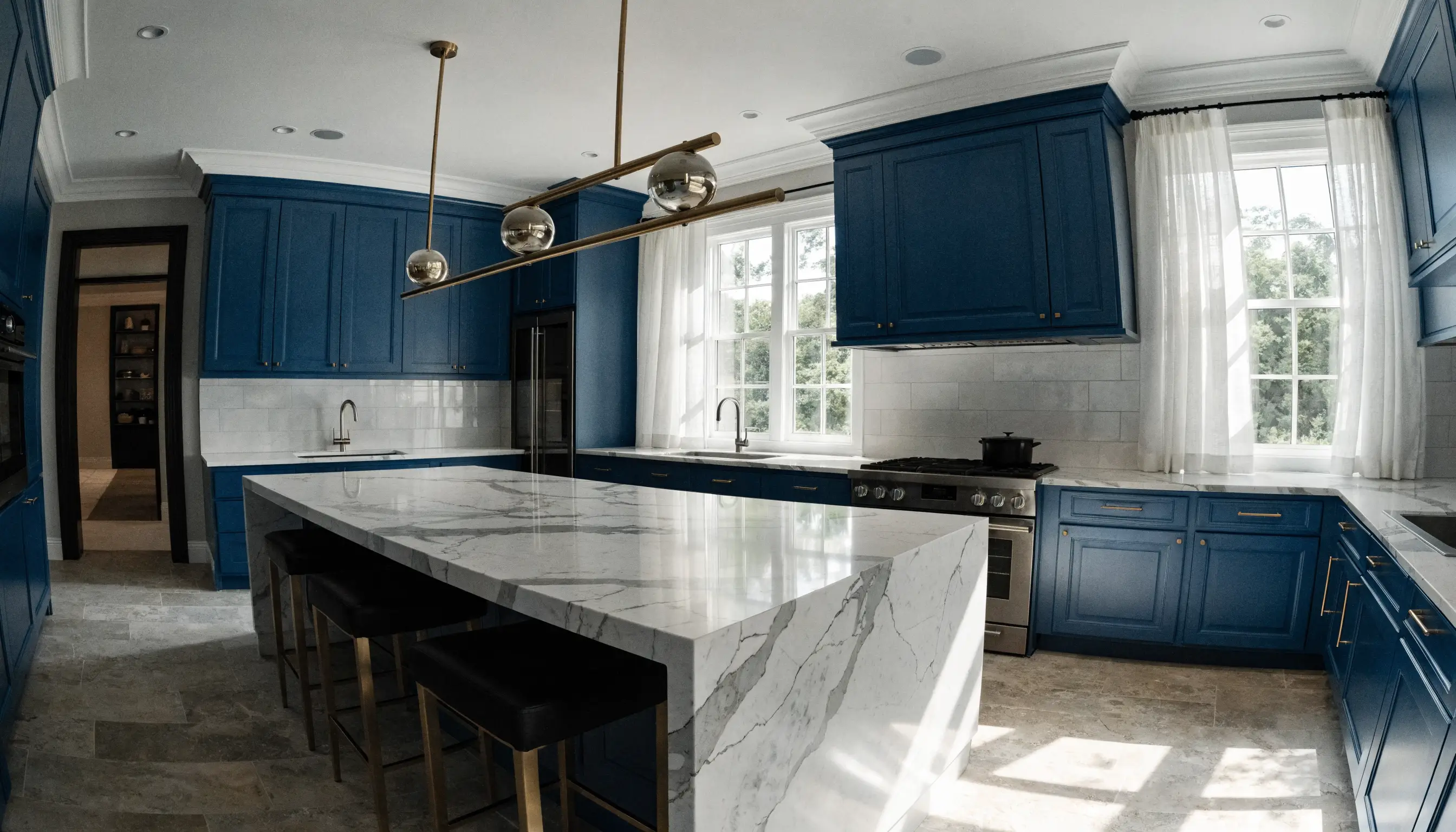 High-end kitchen renovation with navy blue cabinetry and white marble countertops
