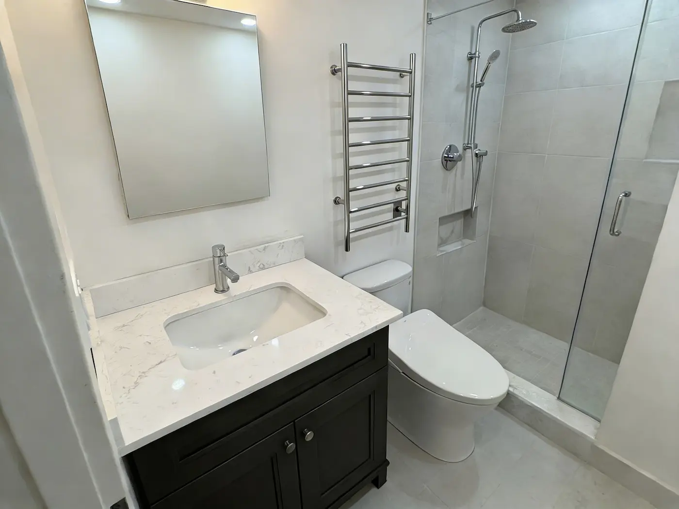 Basement bathroom renovation in Toronto with tiled shower and modern vanity fixtures